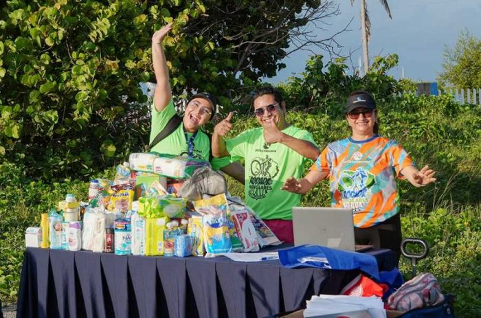 Participantes de la Rodada por los Manglares en Isla Mujeres entregando donaciones a miembros de la Fundación Desde Cero